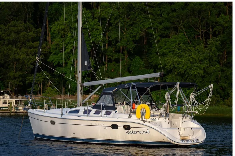 The Image of Sailboat "Waterwind," Hunter 386, 2003 model, anchored near lush green trees. - 0