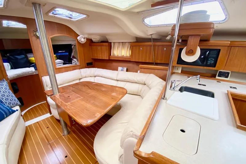 Slide: The Image of Interior of 2003 Hunter 386 sailboat with cozy seating and wooden finishes. - 10