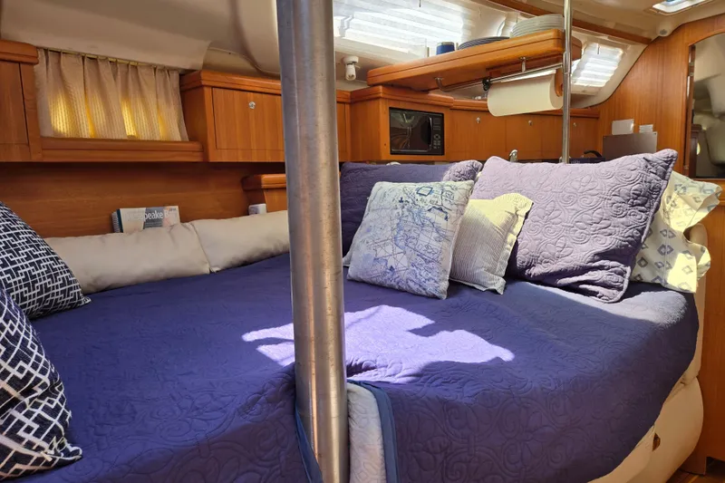 Slide: The Image of Cozy cabin interior of 2003 Hunter 386 sailboat with plush bedding and wooden cabinetry. - 12