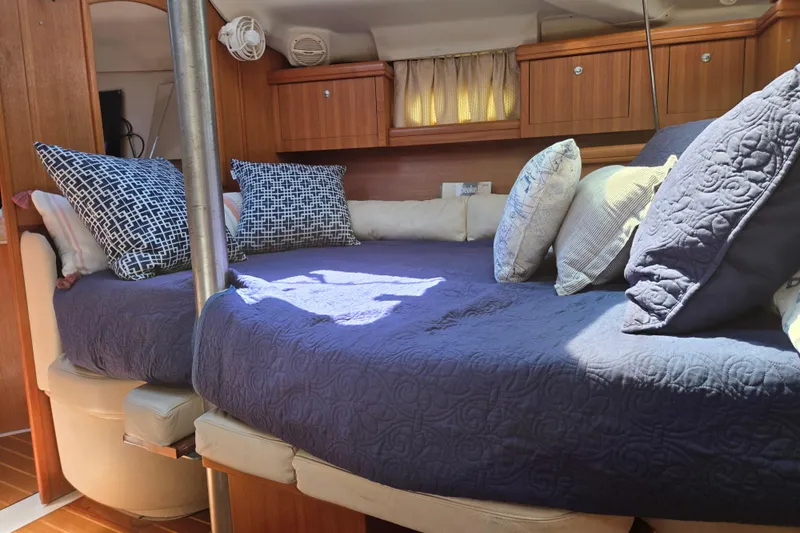 Slide: The Image of Cozy cabin interior of 2003 Hunter 386 sailboat with plush bedding and pillows. - 13