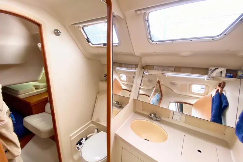 Slide: The Image of Interior of 2003 Hunter 386 sailboat bathroom with sink, toilet, and mirrors. - 15