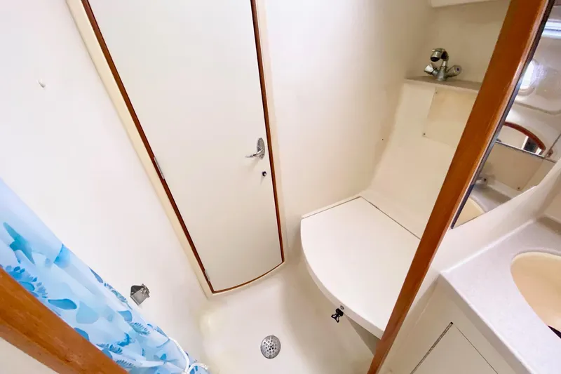 Slide: The Image of Compact bathroom in a 2003 Hunter 386 sailboat, featuring a shower and sink. - 16