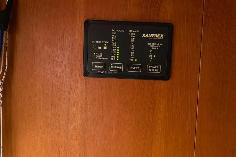 Slide: The Image of Xantrex power control panel on 2003 Hunter 386 sailboat, mounted on wooden surface. - 21