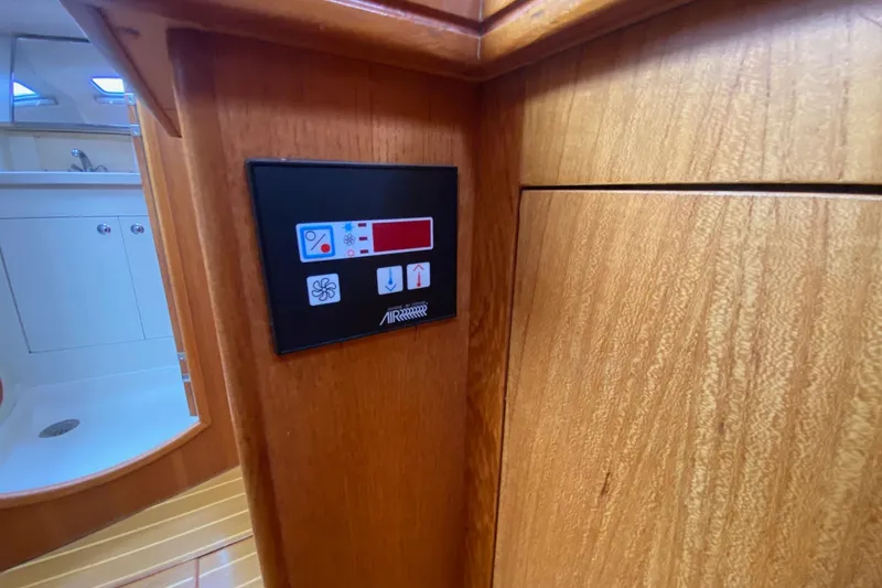 Slide: The Image of Control panel inside 2003 Hunter 386 yacht, featuring wooden interior and bathroom view. - 22