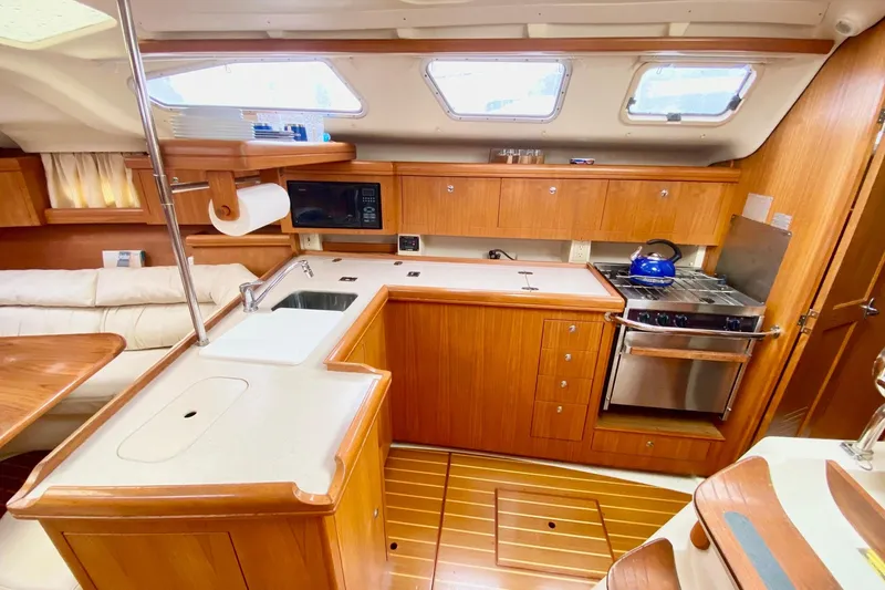 Slide: The Image of Luxurious 2003 Hunter 386 yacht interior with modern kitchen and wooden cabinetry. - 24