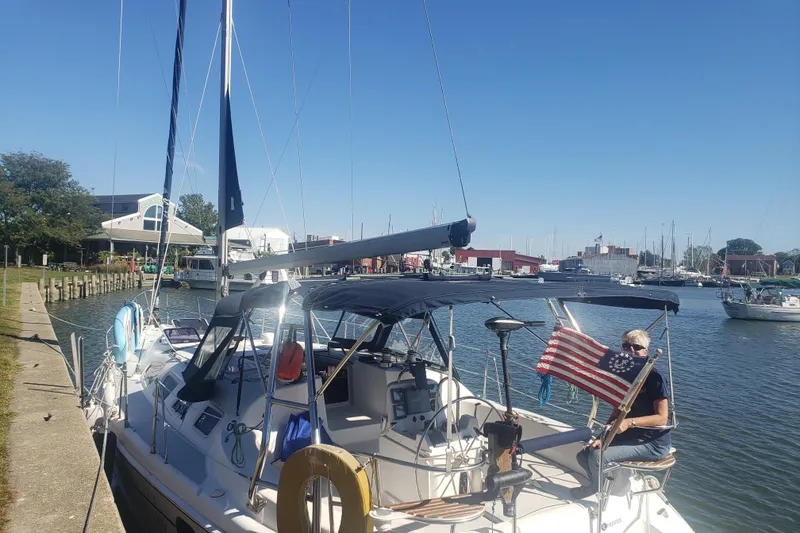 Slide: The Image of 2003 Hunter 386 sailboat docked at marina with person and American flag. - 3