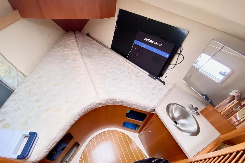 Slide: The Image of 2003 Hunter 386 yacht interior with bed, sink, and solar panel. - 31