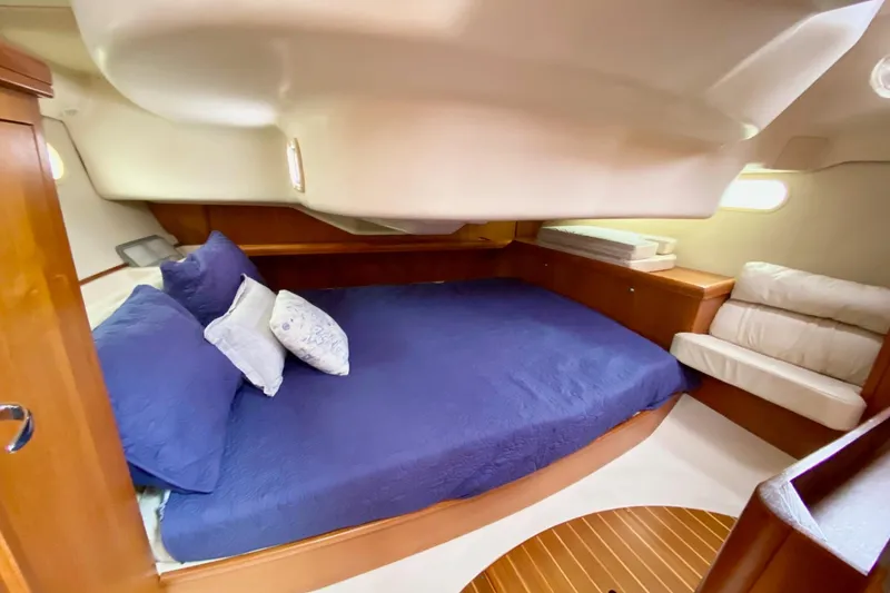Slide: The Image of Luxurious cabin interior of 2003 Hunter 386 yacht with blue bedding and wooden accents. - 34