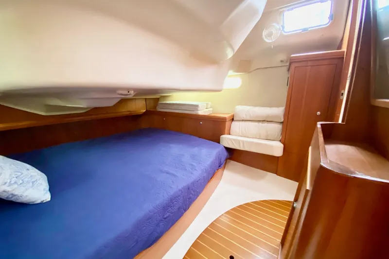 Slide: The Image of Interior cabin of 2003 Hunter 386 sailboat with blue bedding and wooden furnishings. - 35