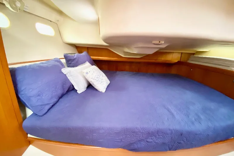 Slide: The Image of Cozy cabin interior of 2003 Hunter 386 sailboat with blue bedding and wooden accents. - 36