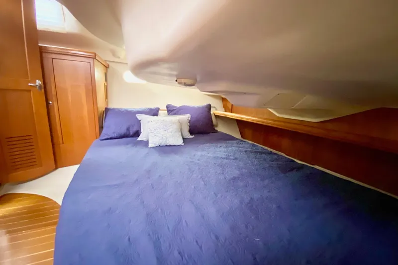Slide: The Image of Cozy cabin interior of 2003 Hunter 386 sailboat with blue bedding and wooden accents. - 37