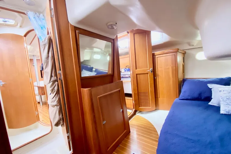 Slide: The Image of Interior of 2003 Hunter 386 sailboat with wooden cabinetry and blue bedding. - 38