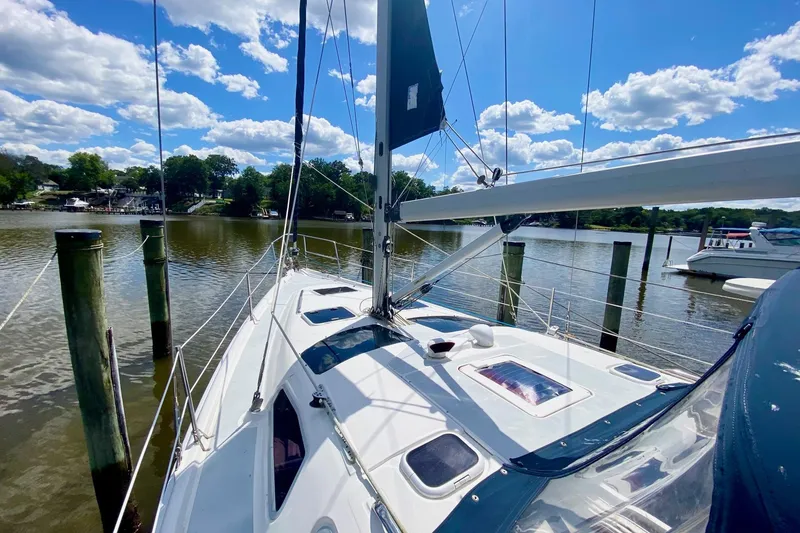 Slide: The Image of 2003 Hunter 386 sailboat docked on a sunny day with blue skies and clouds. - 44