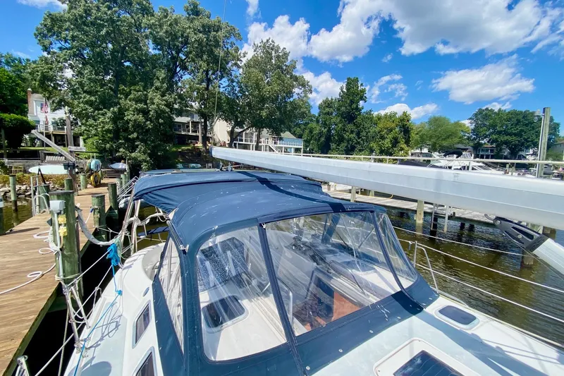 Slide: The Image of 2003 Hunter 386 sailboat docked at a marina under a clear blue sky. - 53