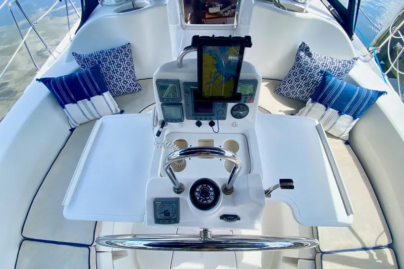Slide: The Image of Cockpit of 2003 Hunter 386 sailboat with navigation equipment and blue-striped cushions. - 56