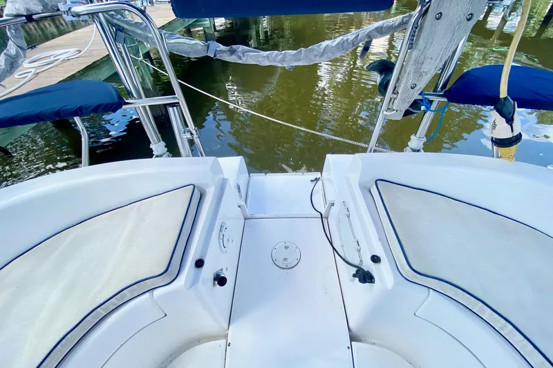 Slide: The Image of Cockpit view of a 2003 Hunter 386 sailboat, featuring seating and marina backdrop. - 58