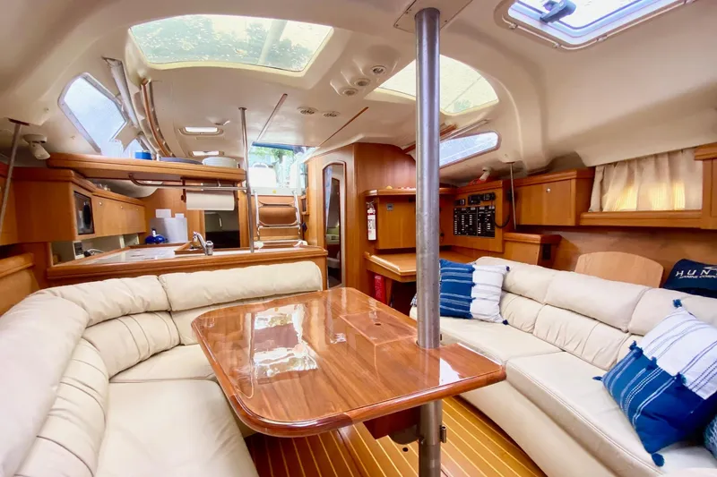 Slide: The Image of Luxurious interior of 2003 Hunter 386 sailboat with plush seating and wooden finishes. - 6