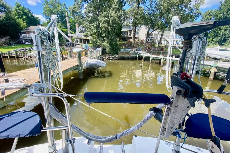 Slide: The Image of Sailboat docked at a marina, surrounded by trees and waterfront homes, Hunter 386, 2003 model. - 60