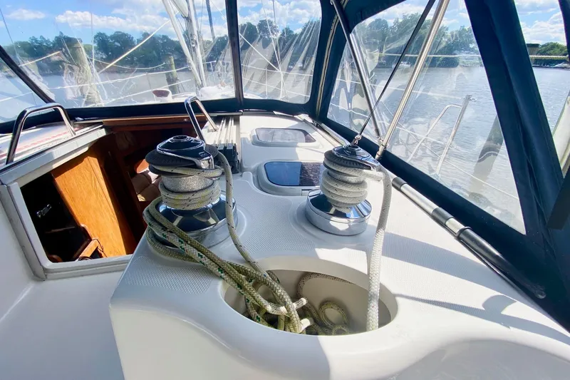 Slide: The Image of 2003 Hunter 386 sailboat cockpit with winches and ropes, docked by the water. - 64
