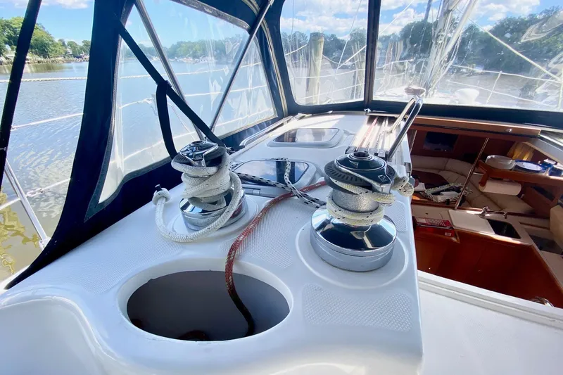 Slide: The Image of 2003 Hunter 386 sailboat cockpit with winches and ropes, overlooking serene waterway. - 65