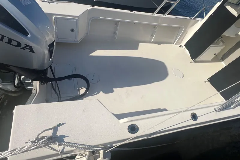 Slide: The Image of 2022 May-Craft 2300 Pilot House boat deck with Honda outboard motor. - 2