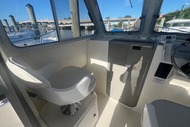 Slide: The Image of Interior of 2022 May-Craft 2300 Pilot House boat with seating and controls. - 6
