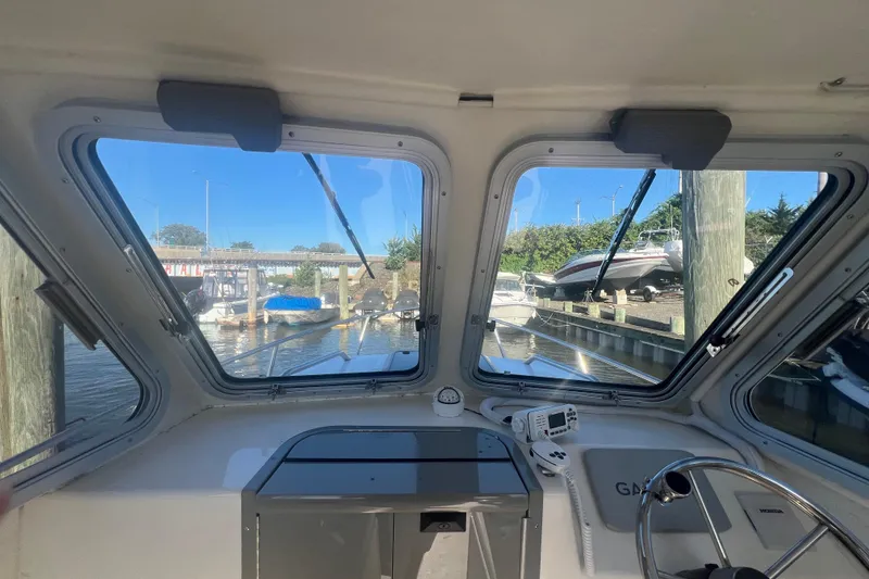 Slide: The Image of Interior view of 2022 May-Craft 2300 Pilot House boat at a marina. - 8