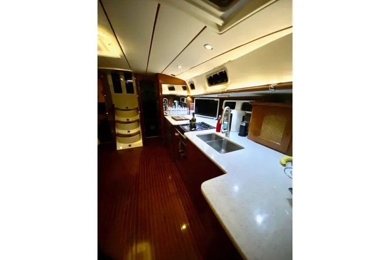Slide: The Image of Interior of 1997 Beneteau Oceanis 461 yacht, featuring a modern kitchen with sleek countertops. - 19