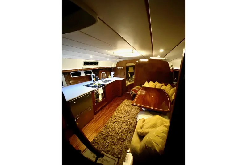 Slide: The Image of Interior of 1997 Beneteau Oceanis 461 yacht, featuring a cozy dining area and modern kitchen. - 21