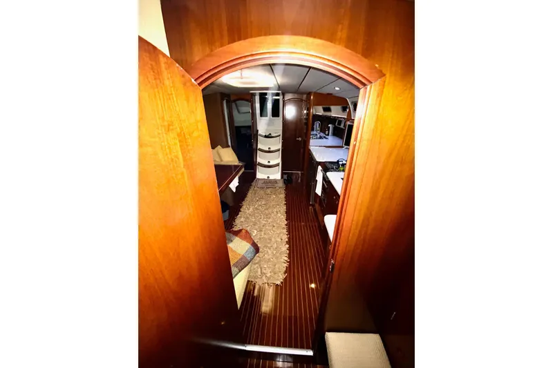 Slide: The Image of Interior view of 1997 Beneteau Oceanis 461 yacht, featuring wood paneling and cozy furnishings. - 24