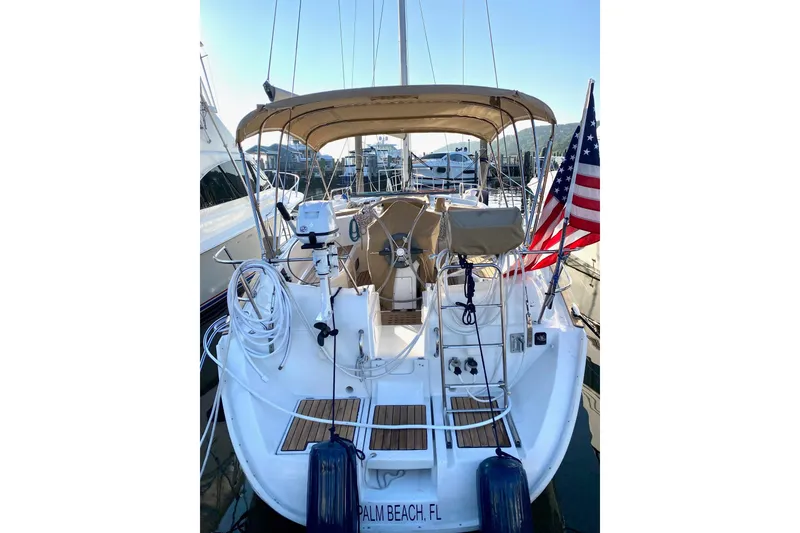 Slide: The Image of 1997 Beneteau Oceanis 461 sailboat docked, featuring American flag and covered cockpit. - 3