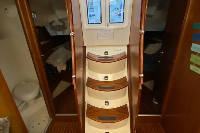 Slide: The Image of Interior view of 1997 Beneteau Oceanis 461 sailboat, featuring wooden steps and cabin access. - 31