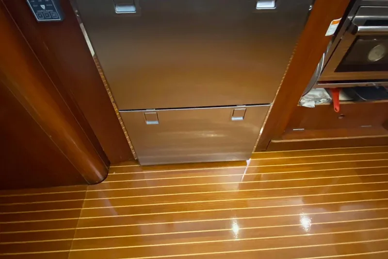 Slide: The Image of Galley of 1997 Beneteau Oceanis 461 with polished wood flooring and stainless steel appliances. - 34