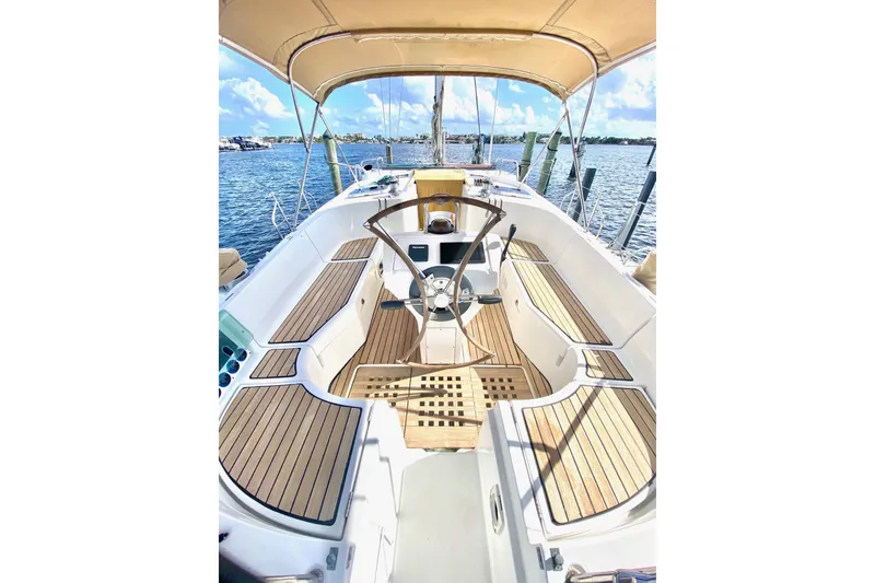 Slide: The Image of 1997 Beneteau Oceanis 461 sailboat cockpit with teak decking and steering wheel, docked by the water. - 4