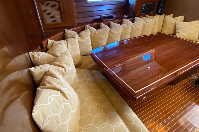 Slide: The Image of Luxurious interior of 1997 Beneteau Oceanis 461 with polished wood table and cushioned seating. - 50