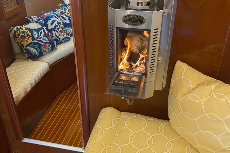Slide: The Image of Cozy interior of 1997 Beneteau Oceanis 461 with a lit fireplace and colorful cushions. - 54