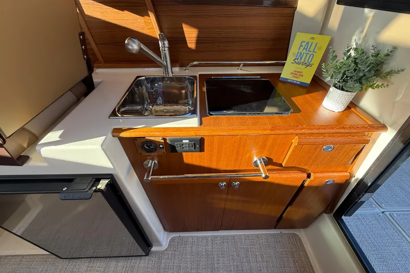 Slide: The Image of Compact kitchen area in 2026 Ranger Tugs R-23 boat with sink, stove, and storage. - 10