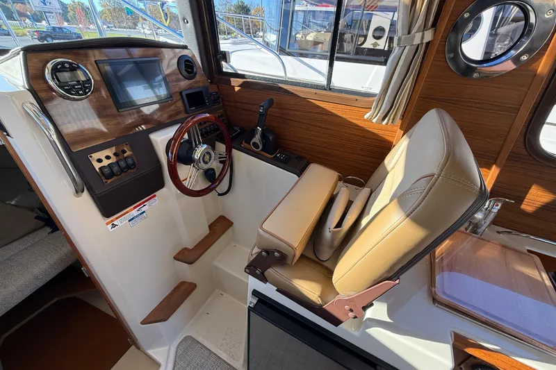 Slide: The Image of Interior of 2026 Ranger Tugs R-23 boat, featuring helm with steering wheel and controls. - 11