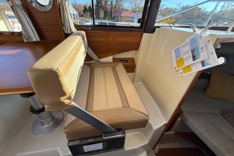 Slide: The Image of 2026 Ranger Tugs R-23 interior with beige seating and wooden accents. - 13