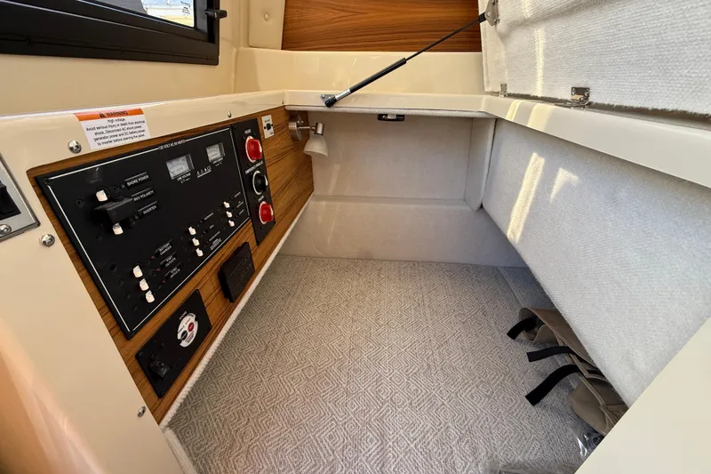 Slide: The Image of 2026 Ranger Tugs R-23 interior cabin with control panel and storage space. - 17