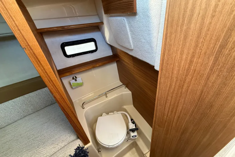 Slide: The Image of 2026 Ranger Tugs R-23 boat interior with compact bathroom and wooden finish. - 21