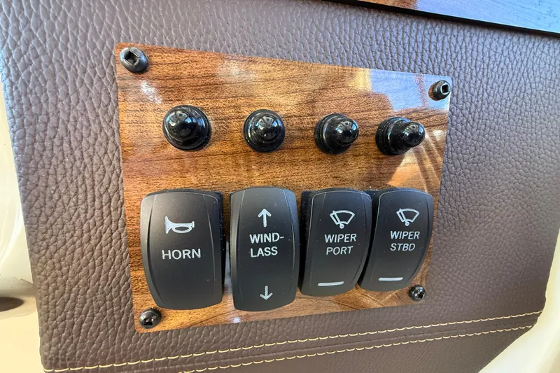 Slide: The Image of Control panel of 2026 Ranger Tugs R-23 with switches for horn, windlass, and wipers. - 23