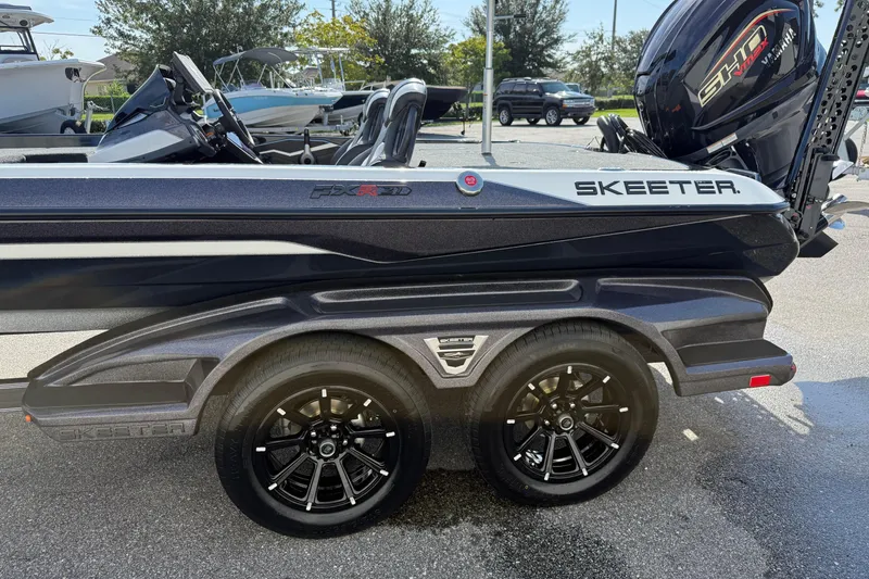 Slide: The Image of 2026 Skeeter FXR21 FLEX boat on trailer with Yamaha engine, parked outdoors. - 4