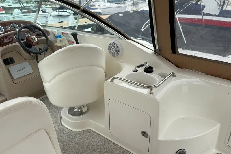 Slide: The Image of 2003 Sea Ray 260 Sundancer boat interior with helm, seating, and sink area. - 10