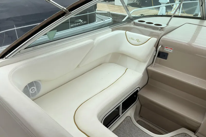 Slide: The Image of 2003 Sea Ray 260 Sundancer interior with white seating and speaker, docked near Bennington. - 11