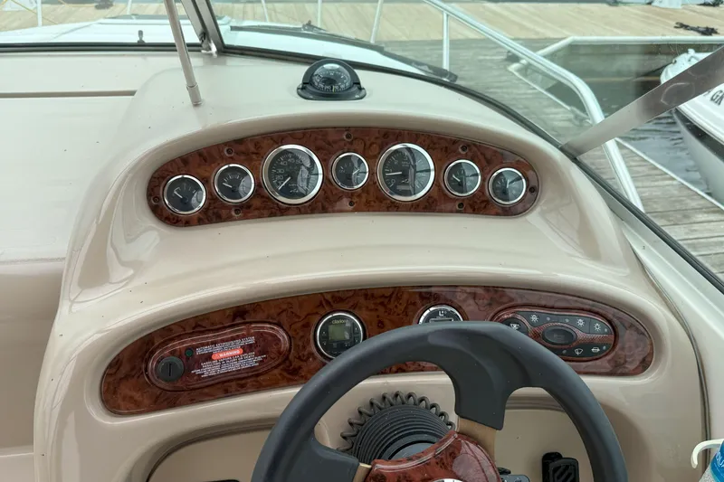 Slide: The Image of Dashboard of a 2003 Sea Ray 260 Sundancer boat with gauges and controls. - 14