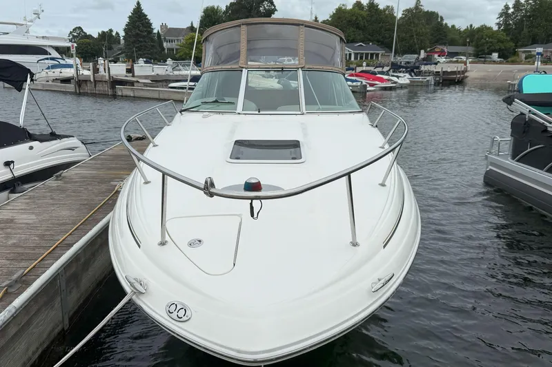 Slide: The Image of 2003 Sea Ray 260 Sundancer docked at marina, front view. - 2