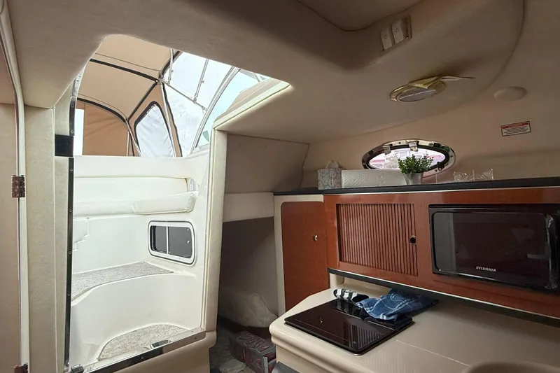 Slide: The Image of Interior of 2003 Sea Ray 260 Sundancer boat with kitchenette and seating area. - 21
