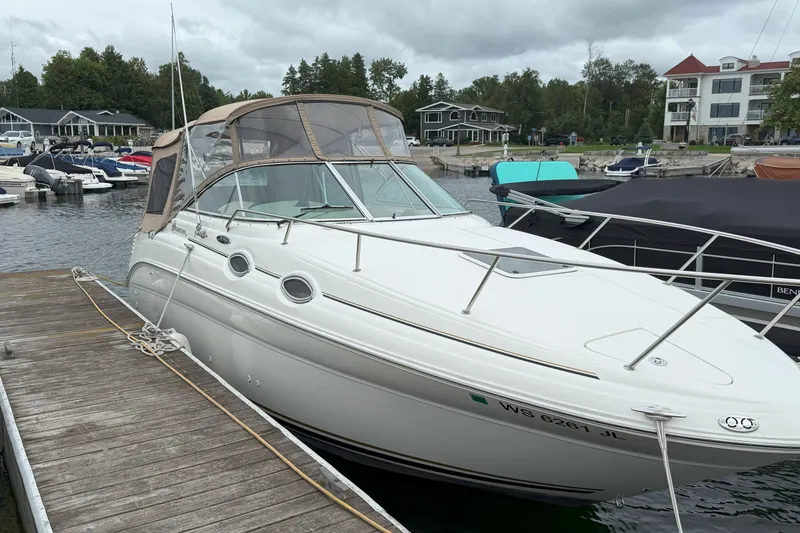 Slide: The Image of 2003 Sea Ray 260 Sundancer docked at a marina, surrounded by other boats. - 3