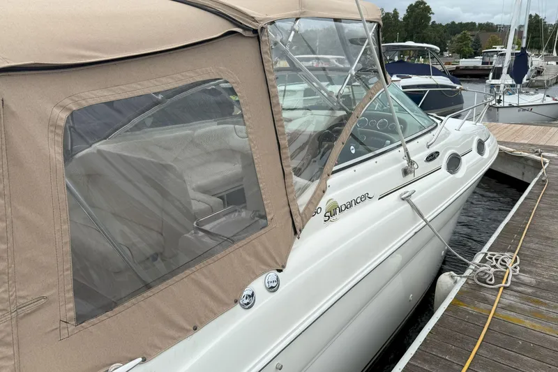Slide: The Image of 2003 Sea Ray 260 Sundancer docked, featuring tan canopy and sleek design. - 5